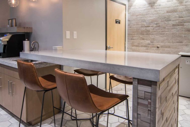 Concrete Countertops and Brown Leather Chairs