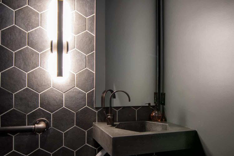 Black hexagon shaped concrete sink and hexagon wall tiles